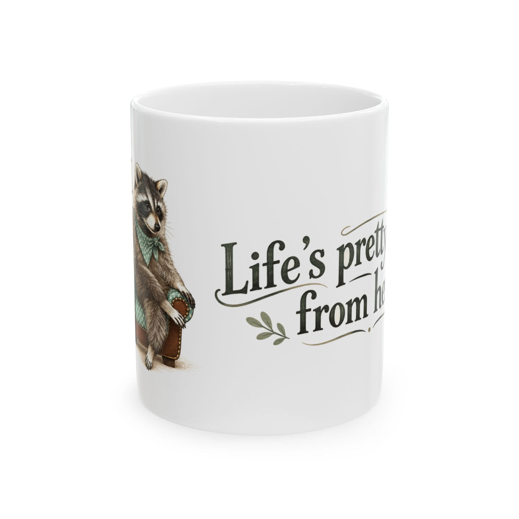 White ceramic mug with Taco the raccoon and the message “Life’s pretty good from here.”
